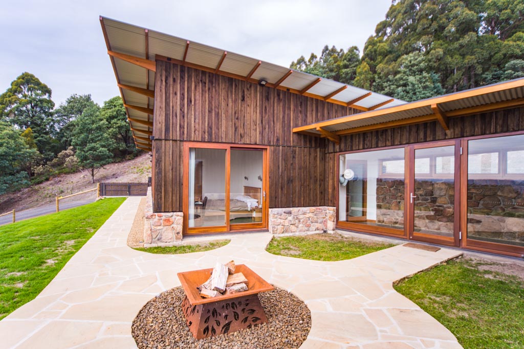 View of guest wing, glass walk way and outdoor firepit